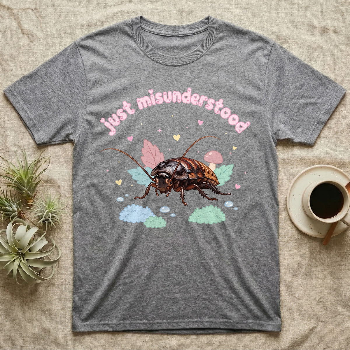 Madagascar Hissing Cockroach Baby T-Shirt in Sport Grey — Pastel Madagascar hissing cockroach among leaves, mushroom and moss, puffy pink wordmark "just misunderstood" above.