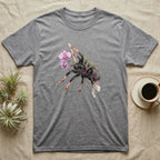 Pink-Toe Tarantula Blossom T-Shirt in Sport Grey — Watercolor illustration of a charcoal pink-toe tarantula with salmon toe tips holding an orchid blossom sprig, on a dark grey t-shirt.