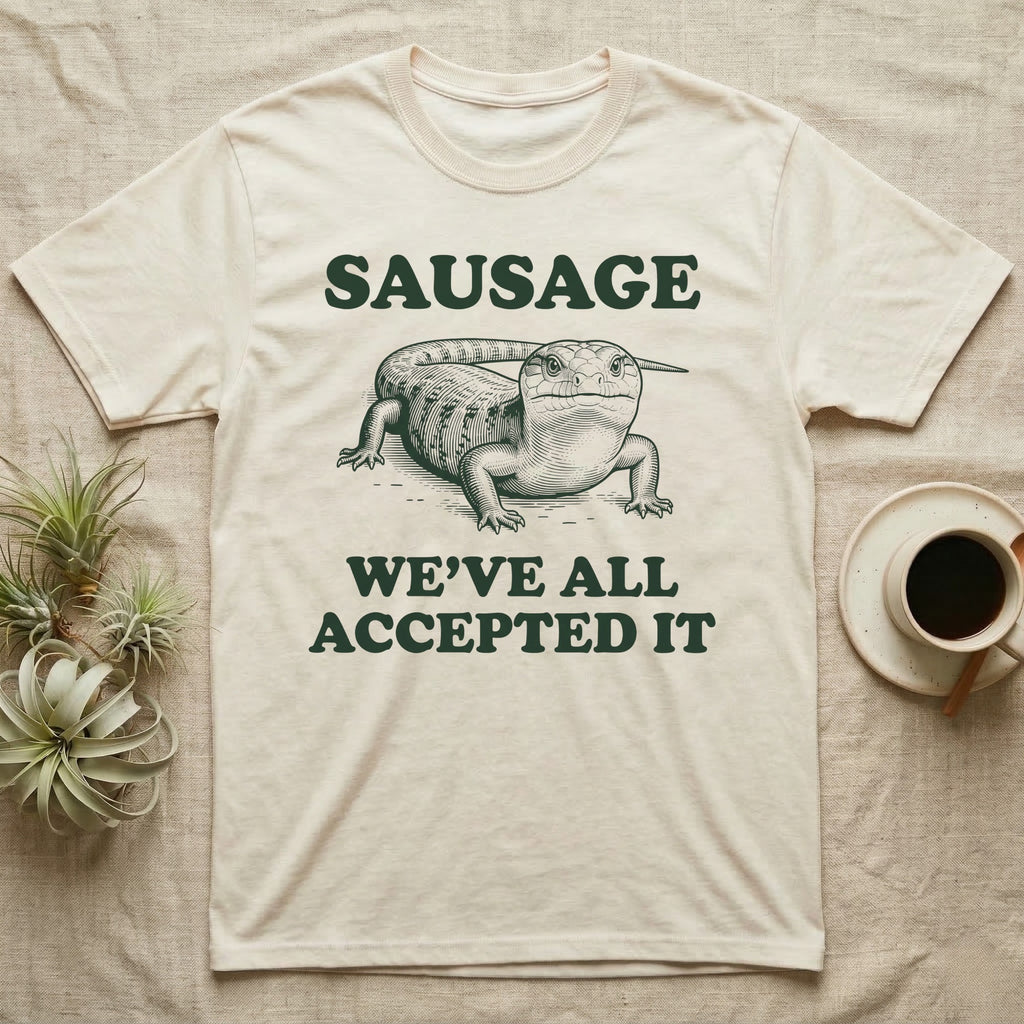 Blue Tongue Skink Sausage T-Shirt in Natural — Antique-engraved blue-tongued skink facing forward, with the word SAUSAGE above and a two-line caption below.