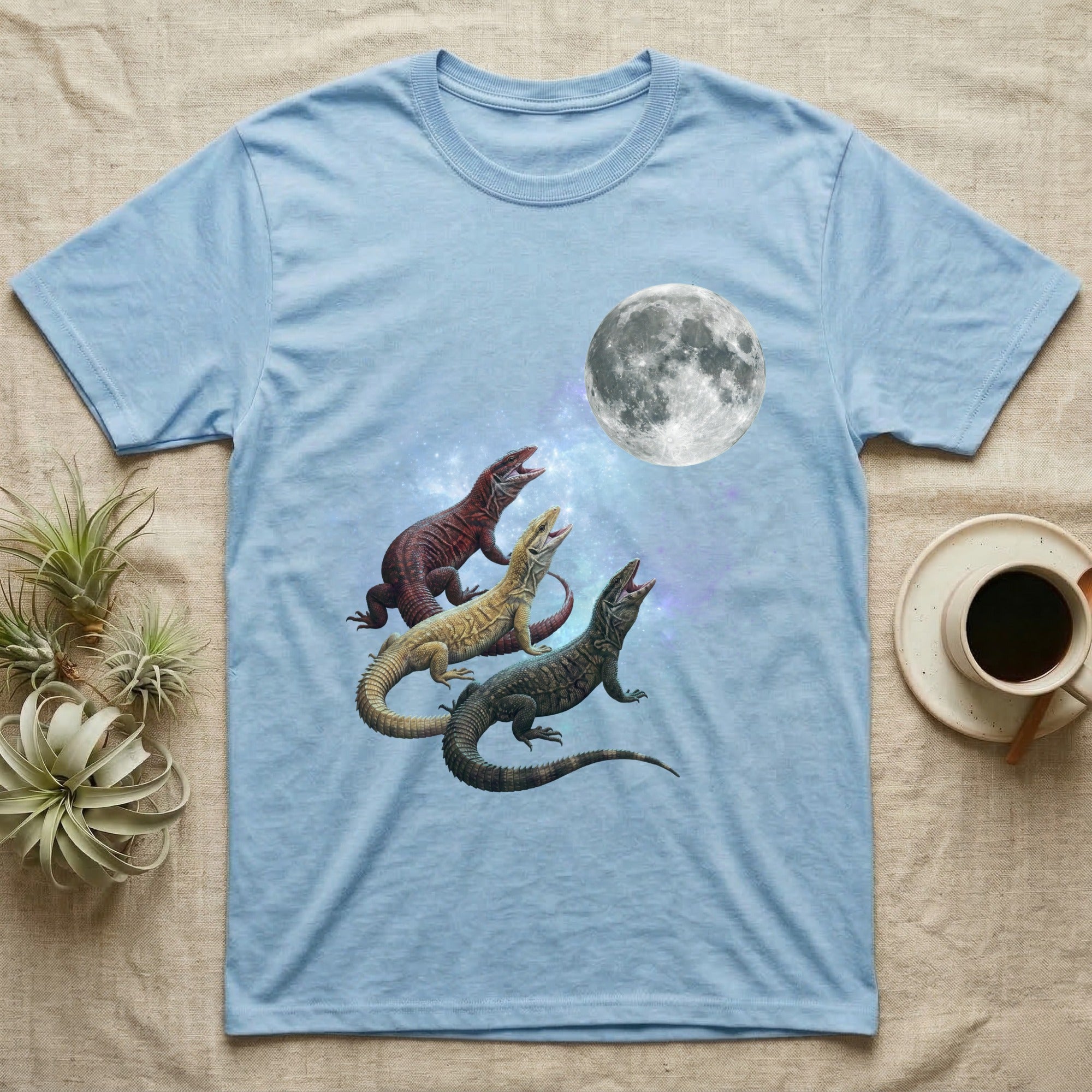 Ackie Monitor Moon Howl T-Shirt in Light Blue — Three Ackie Monitor colour morphs howling at a full moon over a nebula on a dark grey t-shirt.