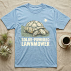 Solar Powered Lawnmower T-Shirt in Light Blue — Retro-illustration of a sulcata tortoise grazing a lawn stripe under a sun motif with a Solar-Powered Lawnmower caption.