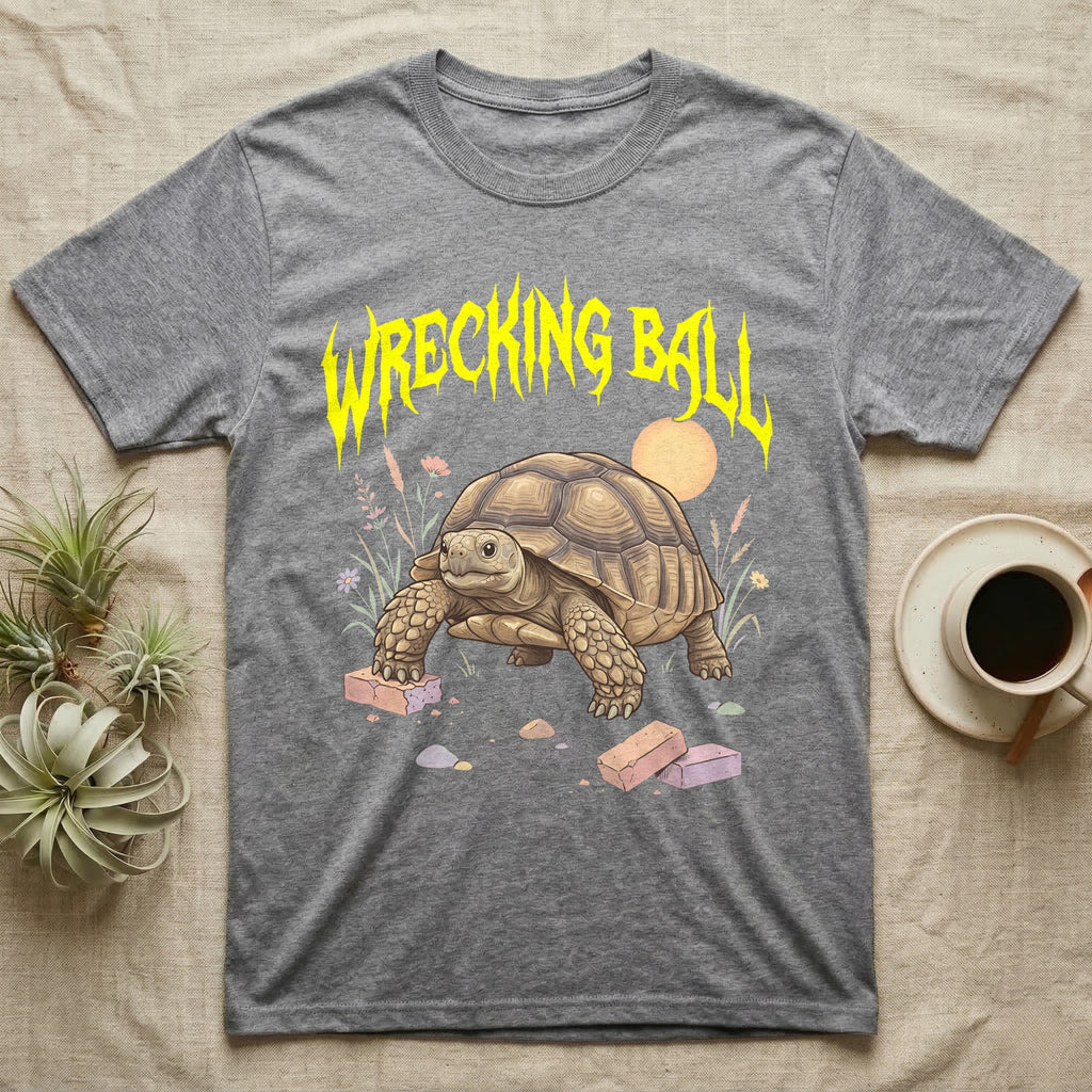 Sulcata Tortoise Feral T-Shirt in Sport Grey — Sulcata tortoise plodding over crumbled bricks under a jagged caution-yellow metal "WRECKING BALL" wordmark.