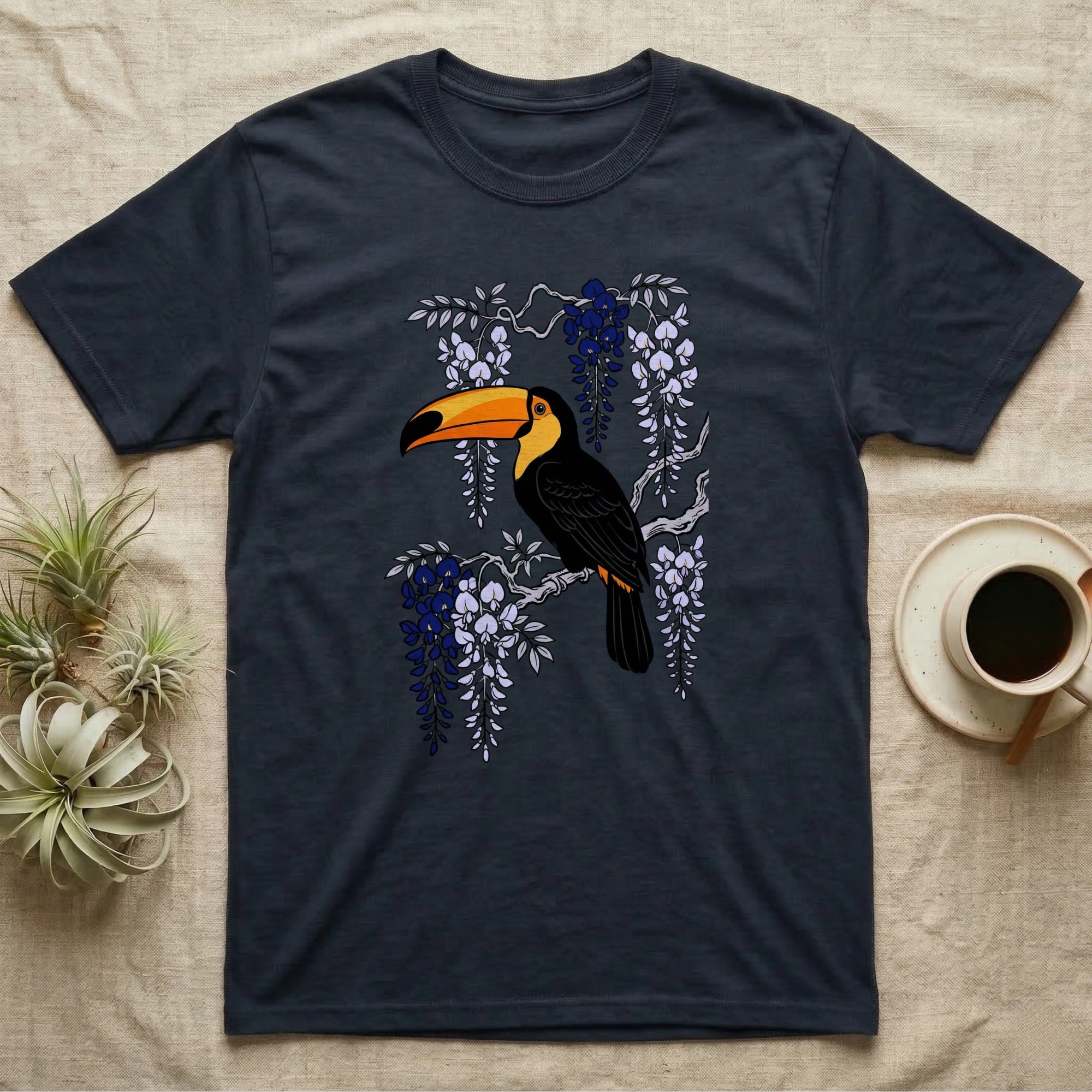 Dark t-shirt with toucan perched on a branch with purple flowers.