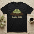 Black t-shirt with a cartoon frog emerging from dirt, text reads "I AM A ROCK."