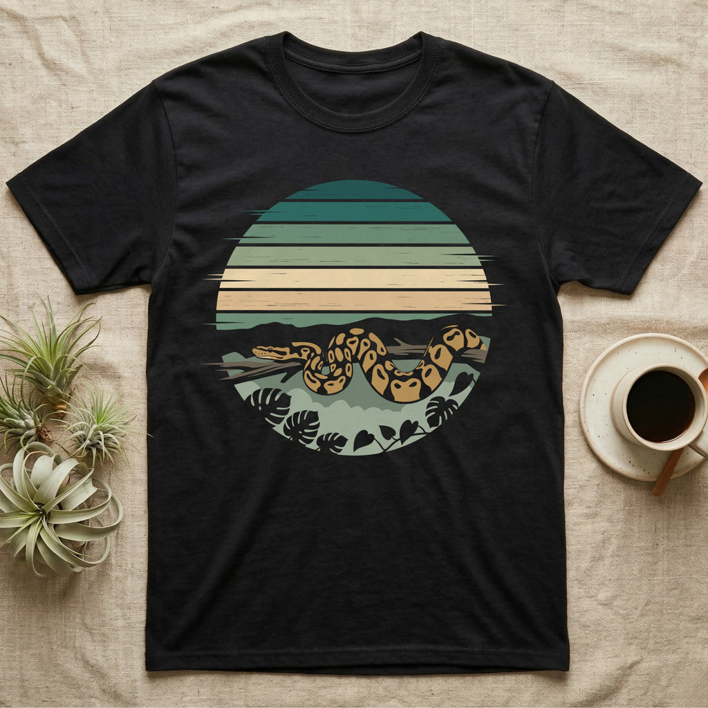 Ball Python Monstera T-Shirt in Black — Ball python coiled through a striped rainforest circle window with monstera and pothos on a near-black tee