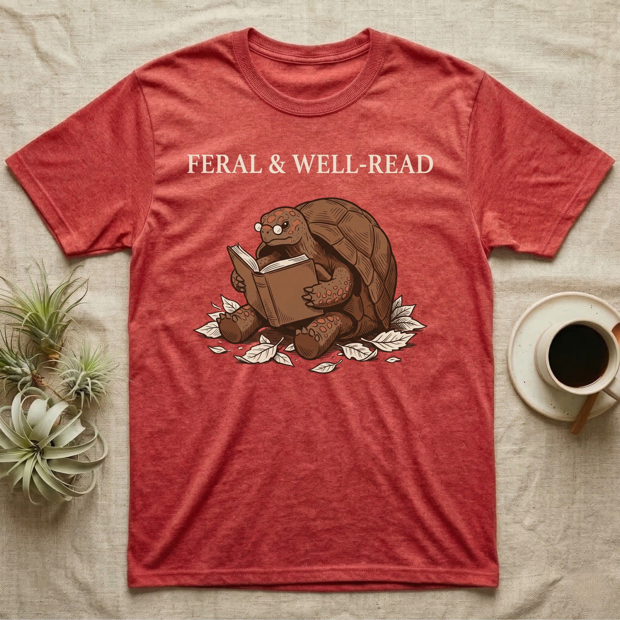 Red-Foot Tortoise Reading T-Shirt in Heather Red — Pen-and-ink red-foot tortoise seated reading a book in tiny glasses with cross-hatch shading and cream ink