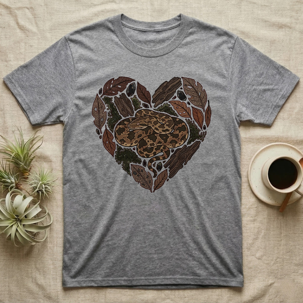 Grey t-shirt with a heart design of a coiled snake and natural elements.