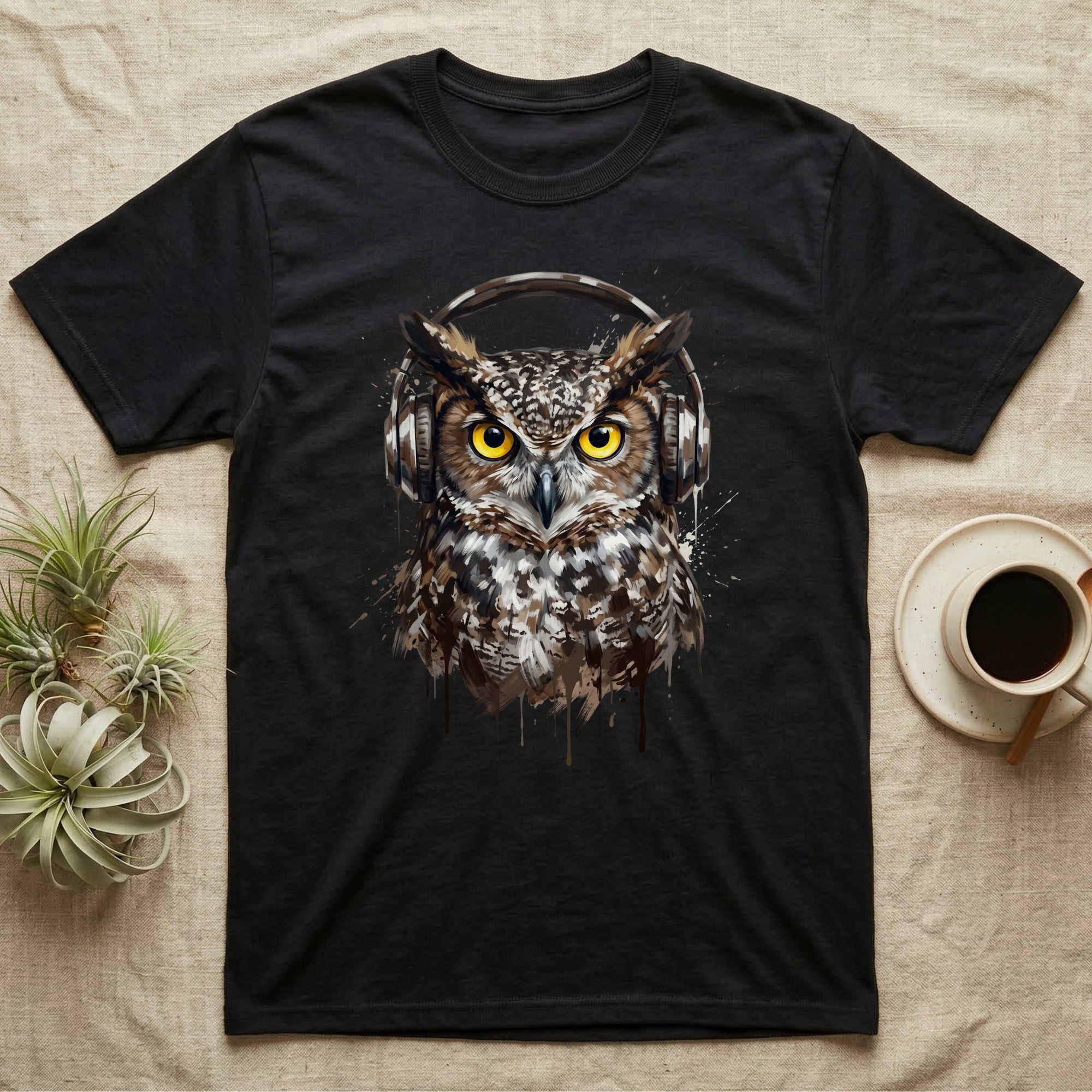 Black t-shirt with a realistic owl wearing headphones, on a neutral background.