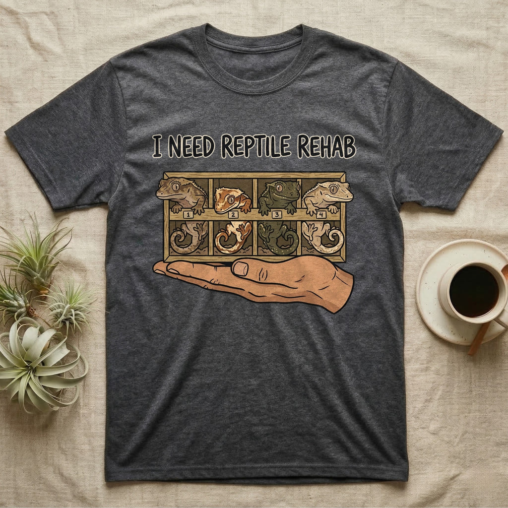Crested Gecko Rehab T-Shirt in Dark Heather — Vector scene of a hand presenting a rack of four crested geckos under a marker-style reptile rehab caption.