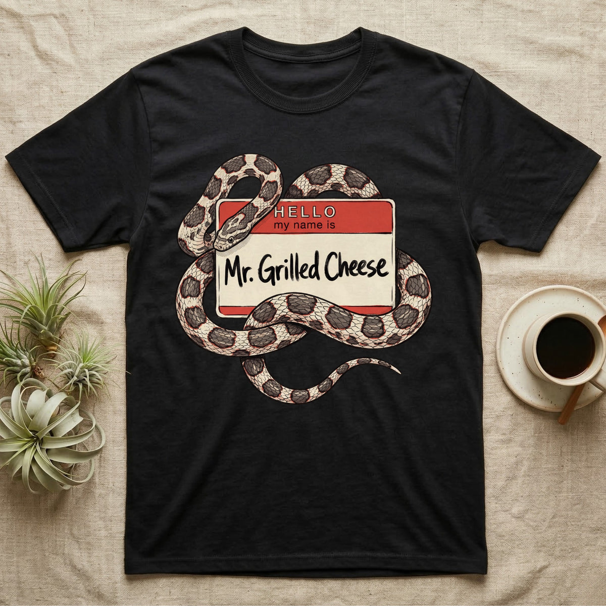 Grilled Cheese Corn Snake T-Shirt in Black — Flat retro illustration of a corn snake coiled through a "Hello my name is Mr. Grilled Cheese" name-tag badge.