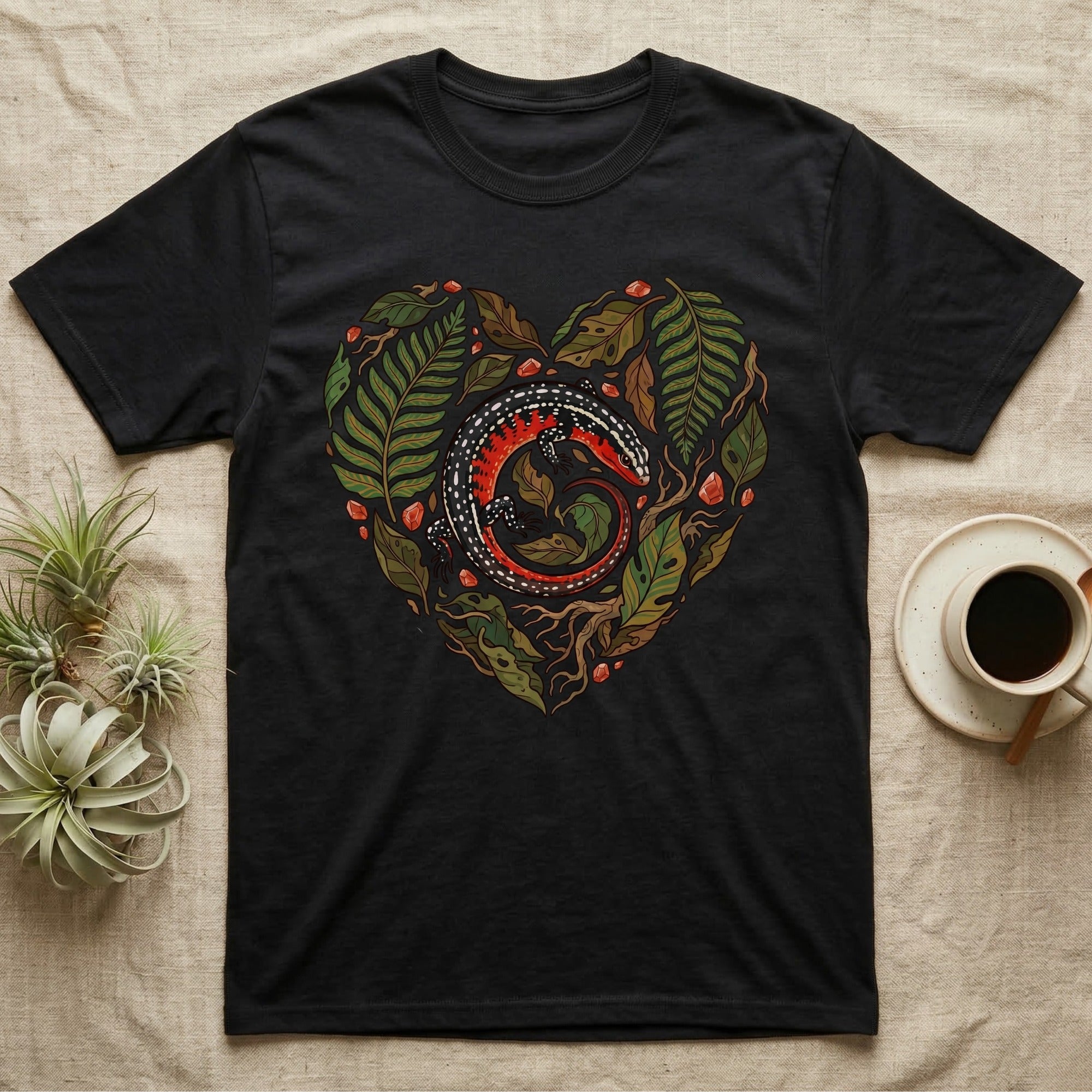 Black t-shirt with a heart-shaped illustration of a gecko surrounded by leaves.