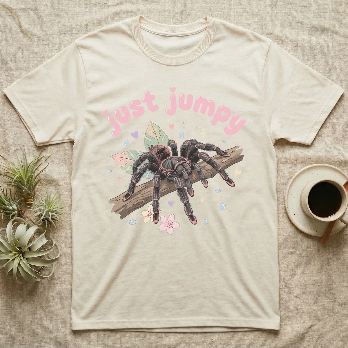 Pink Toe Tarantula Softie T-Shirt in Natural — Pink toe tarantula poised to leap on a branch under a puffy pastel "just jumpy" bubble wordmark with tiny hearts.