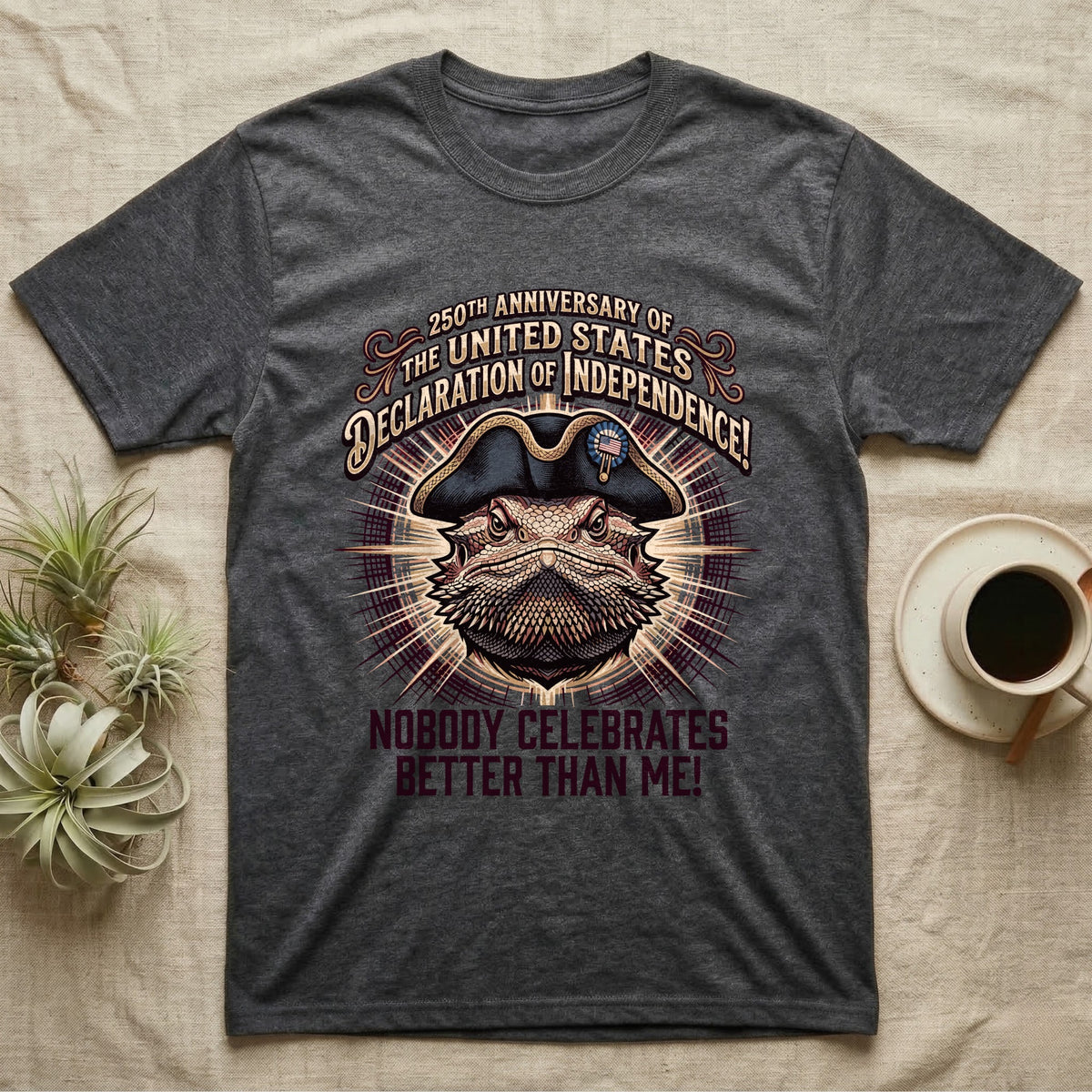 Bearded Dragon Declaration T-Shirt in Dark Heather — Ornate engraved bearded dragon portrait in a tricorn hat on a cream sunburst with Nobody Celebrates Better Than Me.