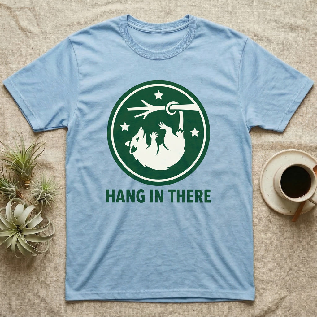 Light blue t-shirt with "HANG IN THERE" and a raccoon hanging from a branch.