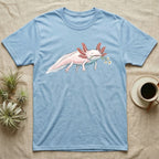 Axolotl Blossom T-Shirt in Light Blue — Watercolor illustration of a pink leucistic axolotl with feathery gills holding an aquatic blossom sprig, on a dark grey t-shirt.