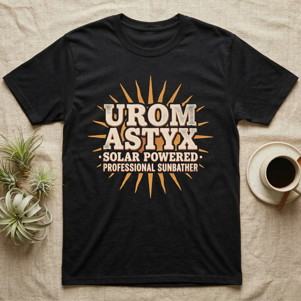 Solar Powered Uromastyx T-Shirt in Black — Desert-poster wordmark reading "Uromastyx Solar Powered Professional Sunbather" with a small radiating sun motif.