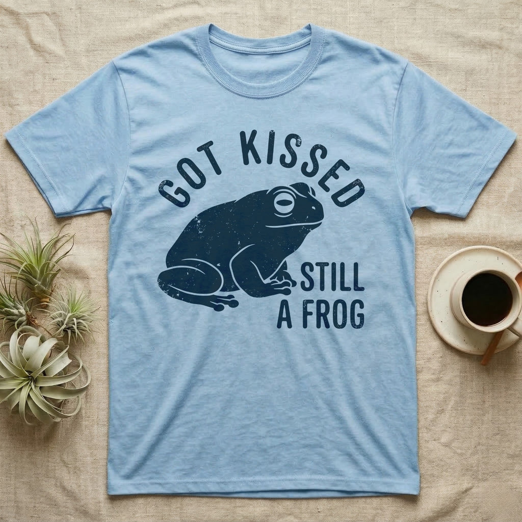 Tree Frog Kissed T-Shirt in Light Blue — Worn navy silhouette of a dumpy White's tree frog under the words Got Kissed Still A Frog