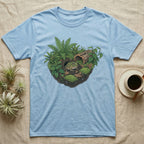 Pacman Frog Vivarium T-Shirt in Light Blue — Botanical illustration of a pacman frog thriving in a planted bioactive vivarium beside a small empty plastic cup.