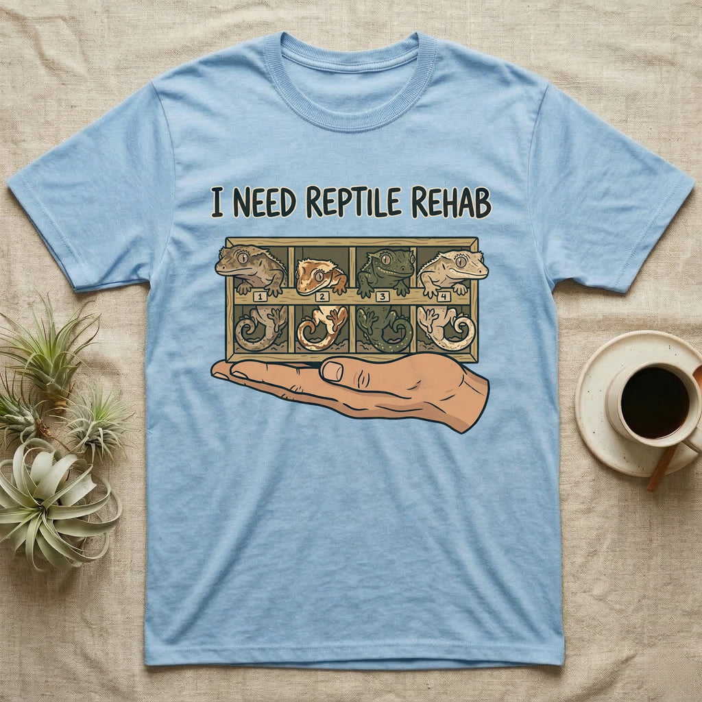 Crested Gecko Rehab T-Shirt in Light Blue — Vector scene of a hand presenting a rack of four crested geckos under a marker-style reptile rehab caption.