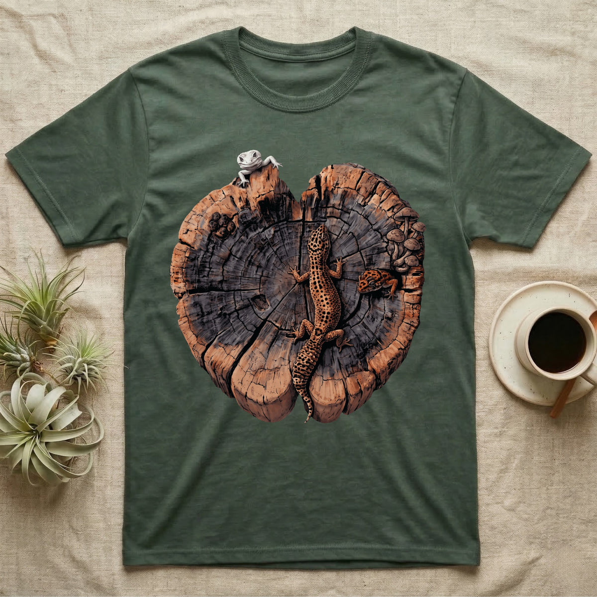 Leopard Gecko Stump Trio T-Shirt in Military Green — Three leopard geckos including a leucistic white morph on a cross-section log slab of amber growth rings with mushrooms, no on-shirt text.
