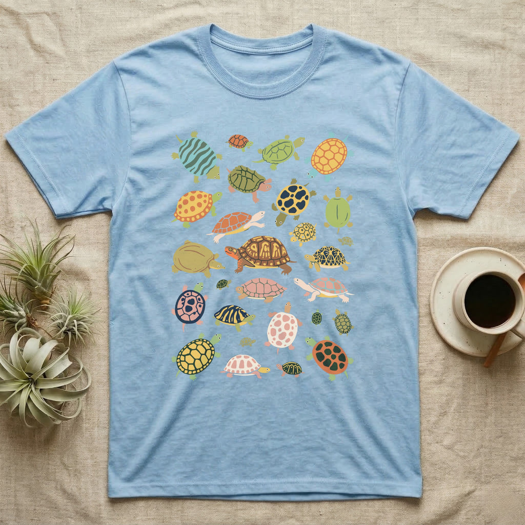 Box Turtle Specimen Plate T-Shirt in Light Blue — Twenty-five turtles and tortoises painted flat in chalky colour, scattered across grey, each facing a different way.