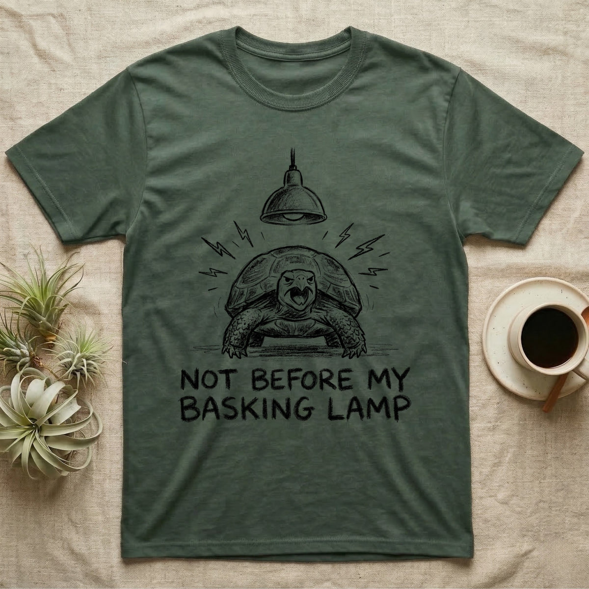 Russian Tortoise Mornings T-Shirt in Military Green — Charcoal drawing of a grumpy Russian tortoise yelling up at a basking lamp above the words NOT BEFORE MY BASKING LAMP.
