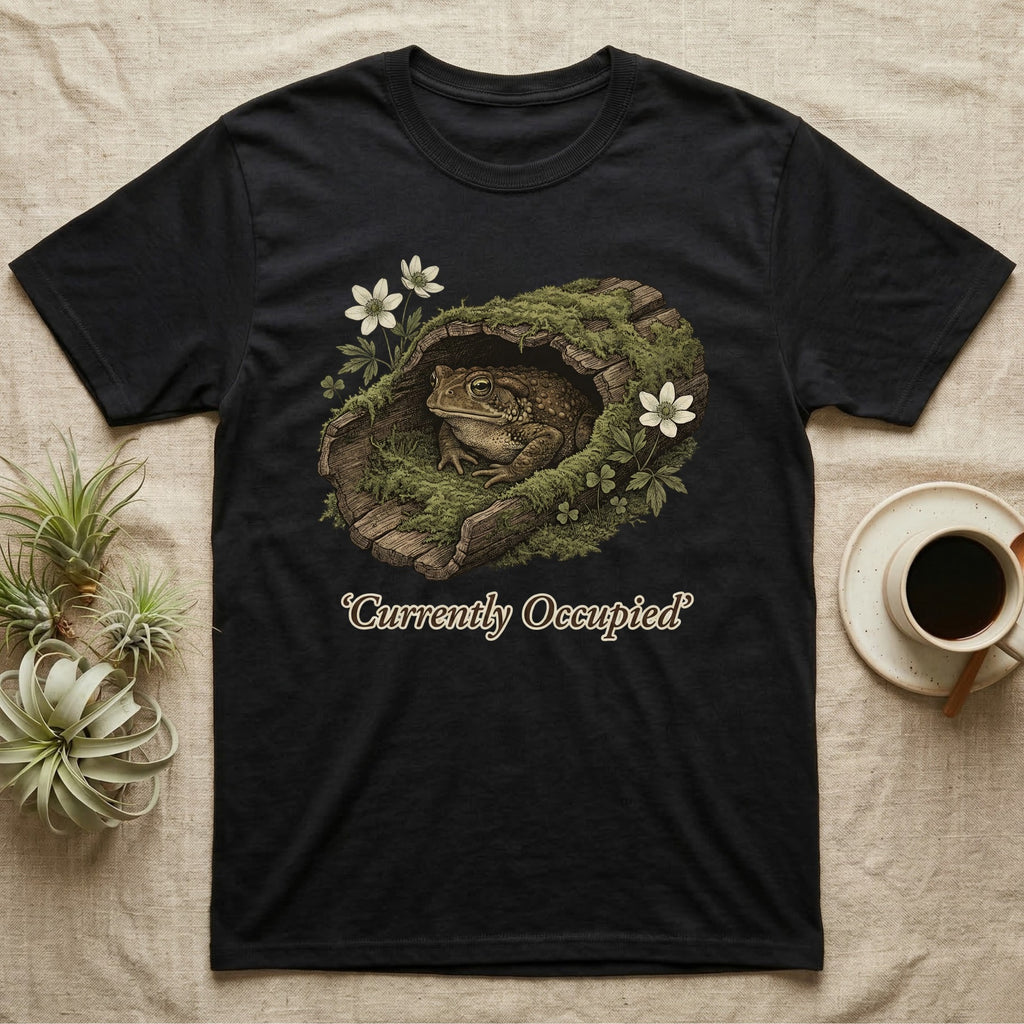 Black t-shirt with a toad inside a mossy log, text says "Currently Occupied".