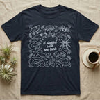 Terrarium Keeper One Tank T-Shirt in Navy — White outline illustration of eleven terrarium species — bearded dragon, crested gecko, ball python, axolotl, tortoise, tarantula, isopod, whip spider, chameleon, tree frog and hognose — with pothos and fern leaves, ringed around the script line it started with one tank.
