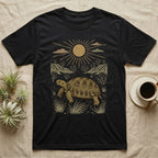 Russian Tortoise Home Range T-Shirt in Black — Woodcut-style illustration of a Russian tortoise walking across gravelly steppe under a full sun with dry hills behind, no on-shirt text.