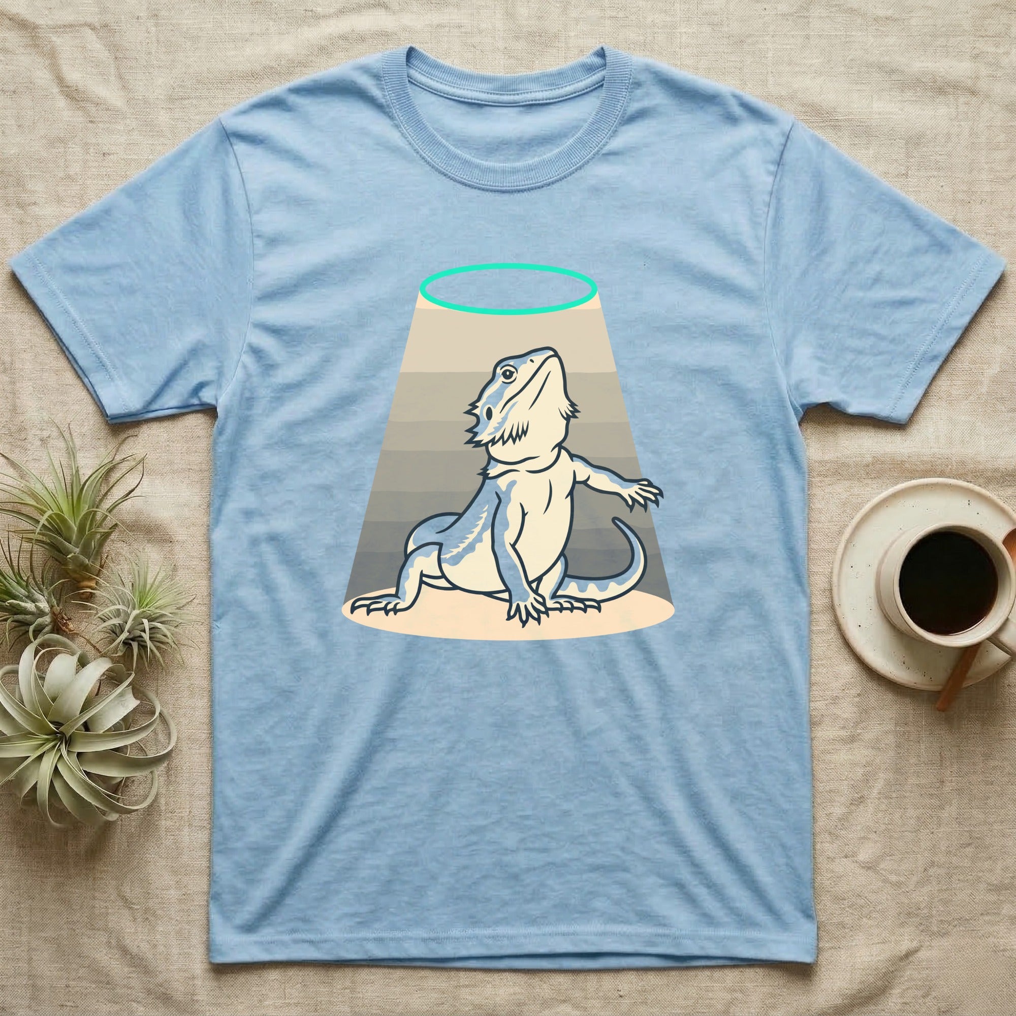 Bearded Dragon Diva T-Shirt in Light Blue — Bold vector illustration of a bearded dragon in a dramatic stage pose under a soft spotlight, chin lifted.
