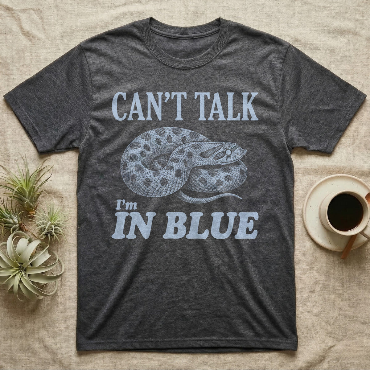 Hognose In Blue T-Shirt in Dark Heather — Milky blue engraved coiled western hognose with a cloudy pre-shed eye on black under the words CAN'T TALK, I'm IN BLUE