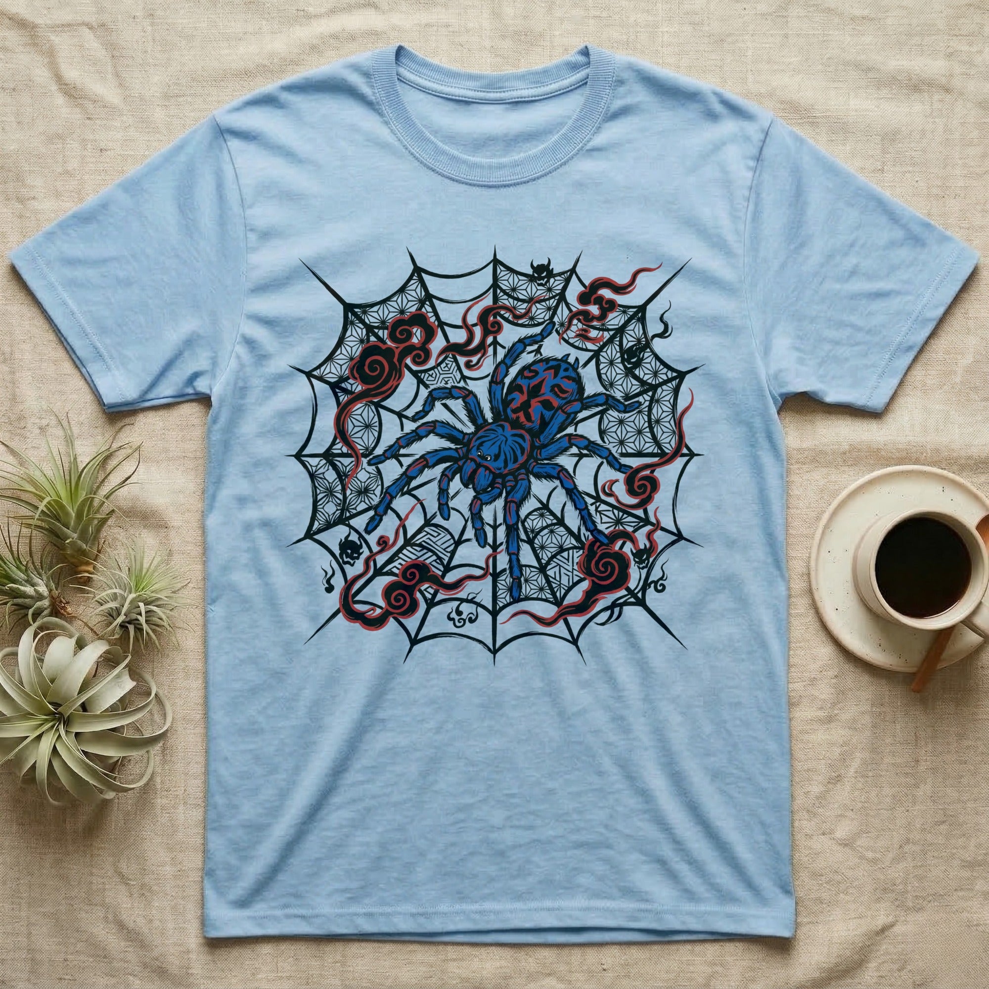 Light blue t-shirt with a blue tarantula on a black web with red accents.
