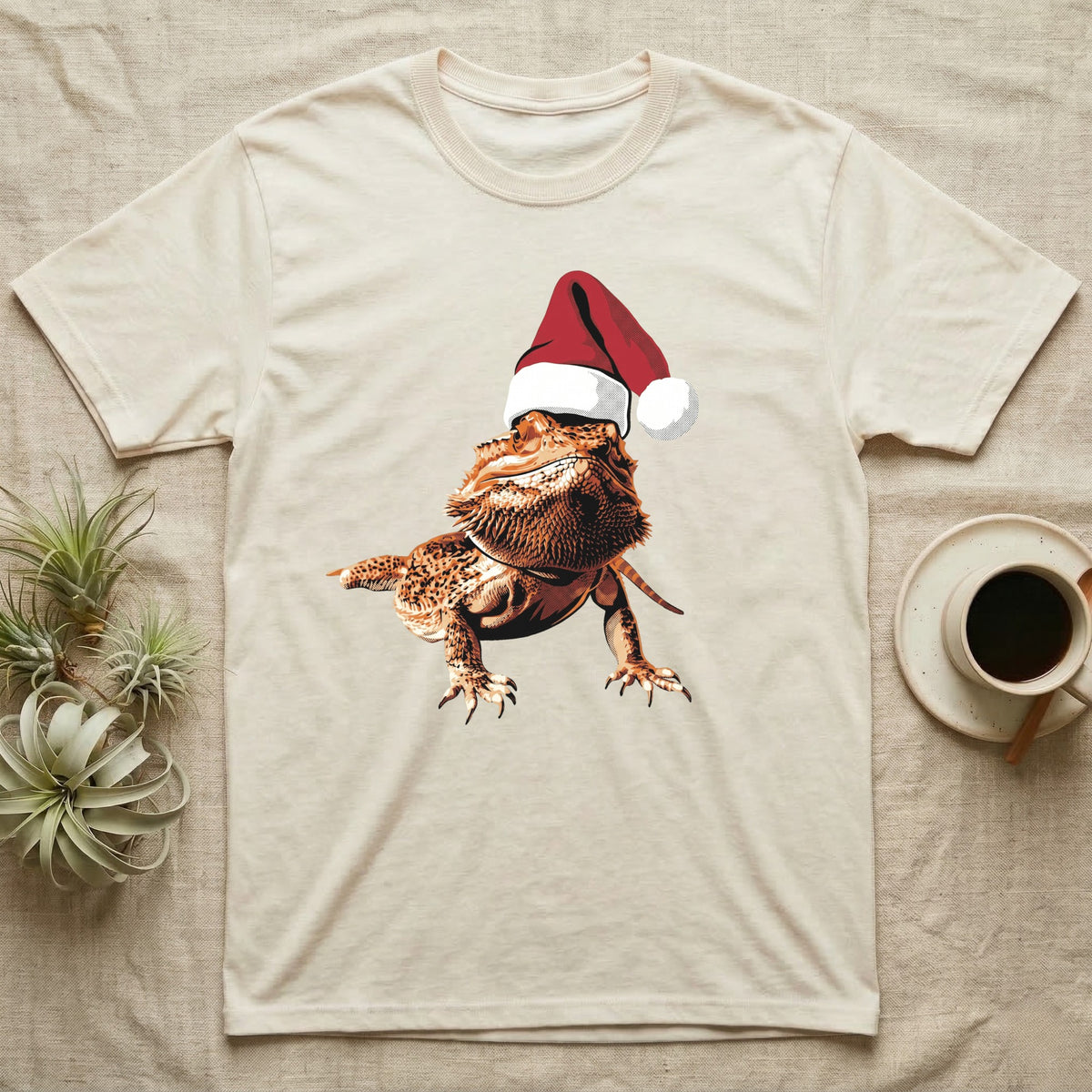 Vintage comic illustration of a bearded dragon wearing a red and white Santa hat, graphic-only, no text. — shown on a Natural tee.
