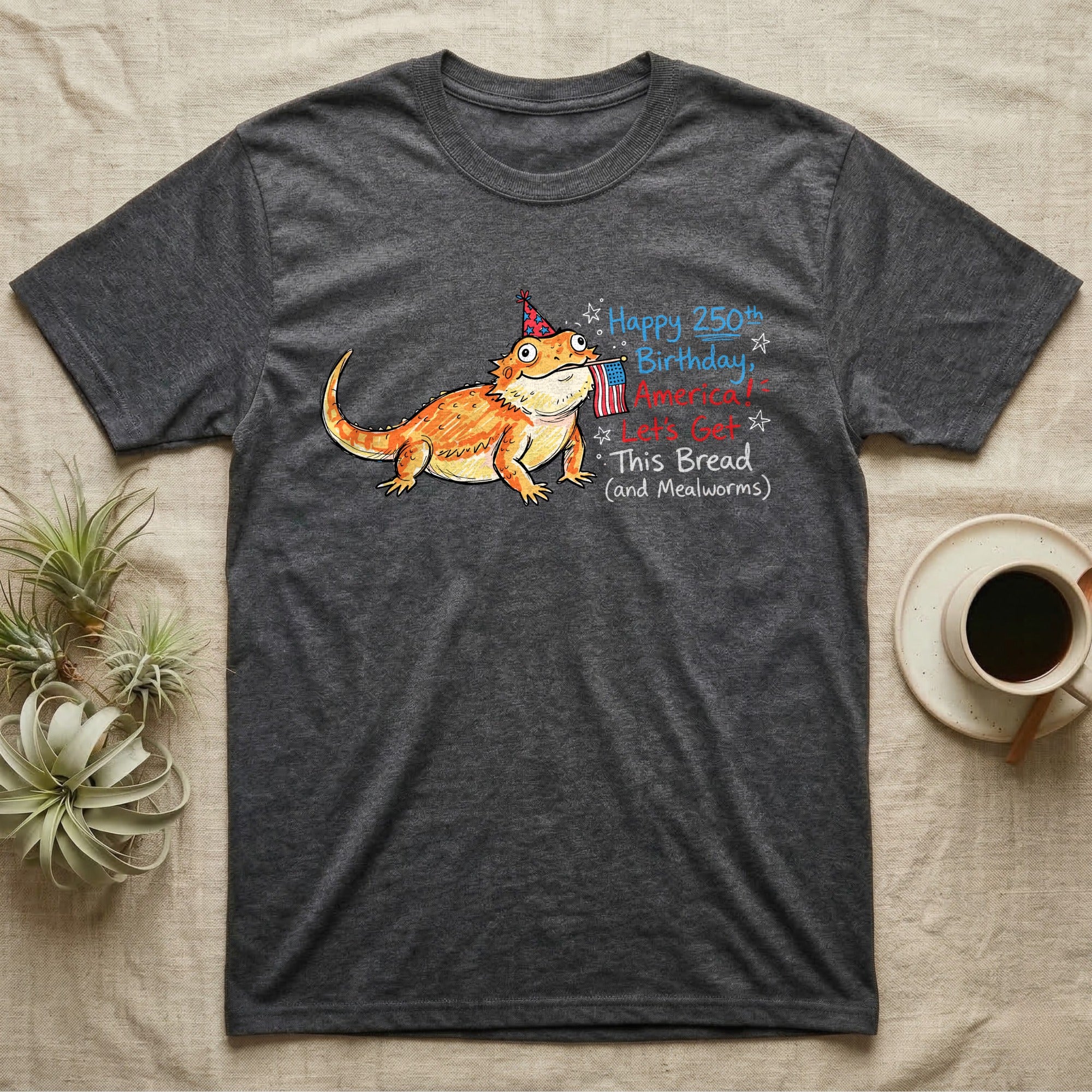 Bearded Dragon Birthday T-Shirt in Dark Heather — Sketch-style bearded dragon in a party hat holding a flag with handwritten text Happy 250th Birthday, America.
