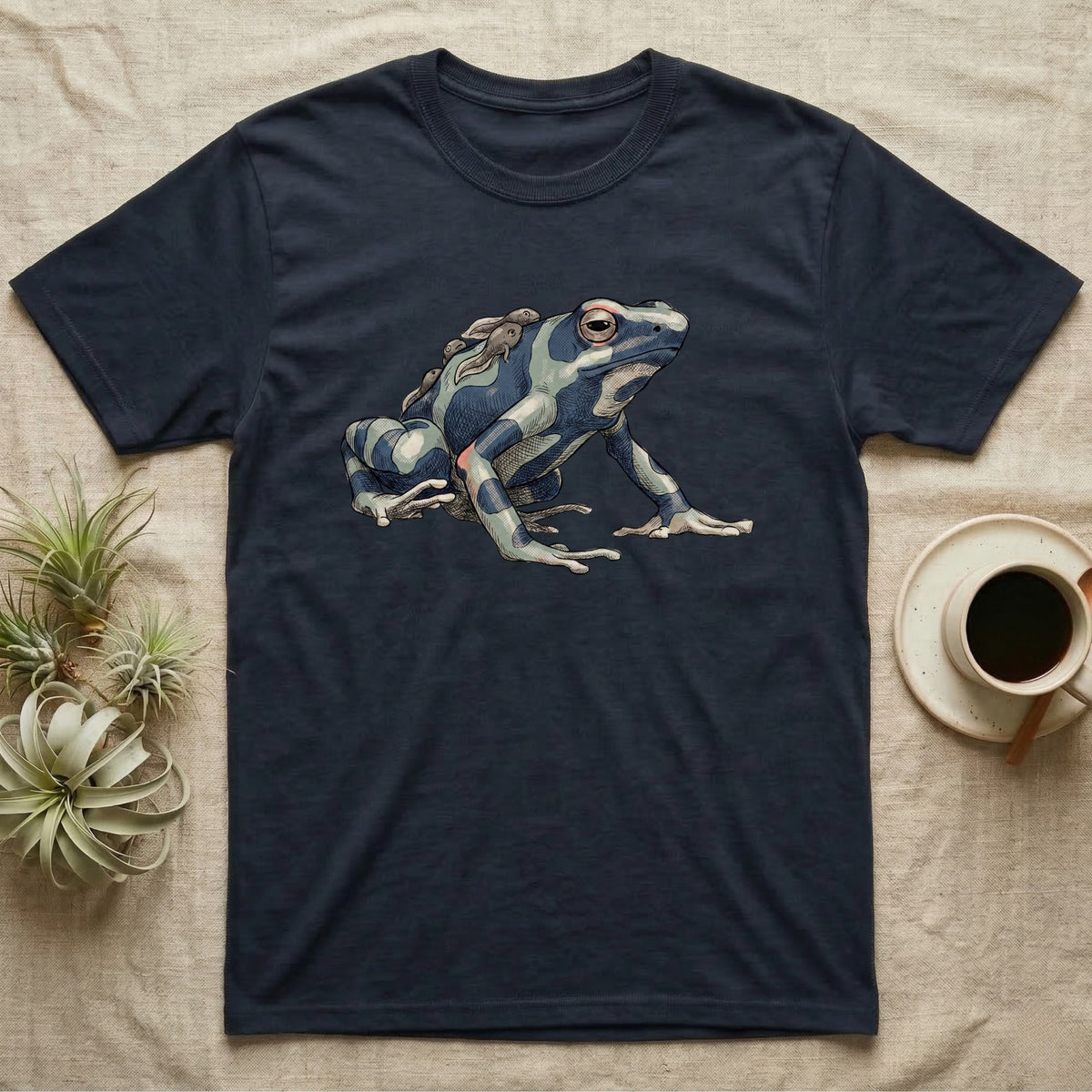 Dart Frog Tadpole T-Shirt in Navy — Naturalist-plate illustration of a dyeing dart frog carrying tadpoles on its back with a dry typewriter caption beside it.
