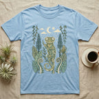 Crested Gecko Rainforest T-Shirt in Light Blue — Linocut-style crested gecko clinging to a branch under a crescent moon, framed by rainforest ferns, pines and leaves.