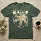 Macro badge illustration of a gecko's splayed foot with ribbed adhesive toe pads inside a distressed circular border, arched wordmark reading GECKO GRIP. — shown on a Military Green tee.