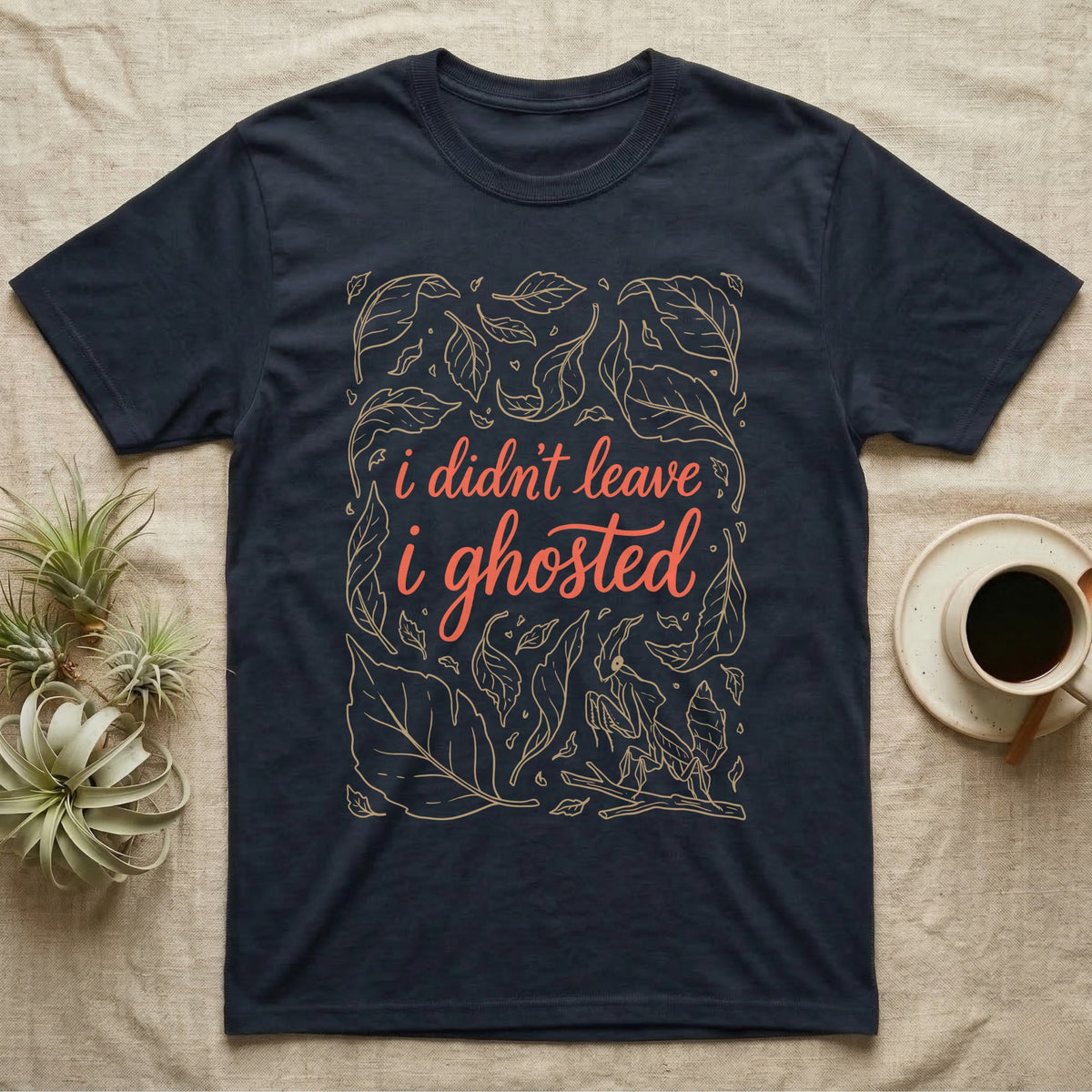 Ghost Mantis Leaf T-Shirt in Navy — Tan outline dead leaves and a hidden ghost mantis around coral script reading i didn't leave, i ghosted.