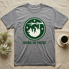 Grey t-shirt with green circular logo and "HANG IN THERE" text.