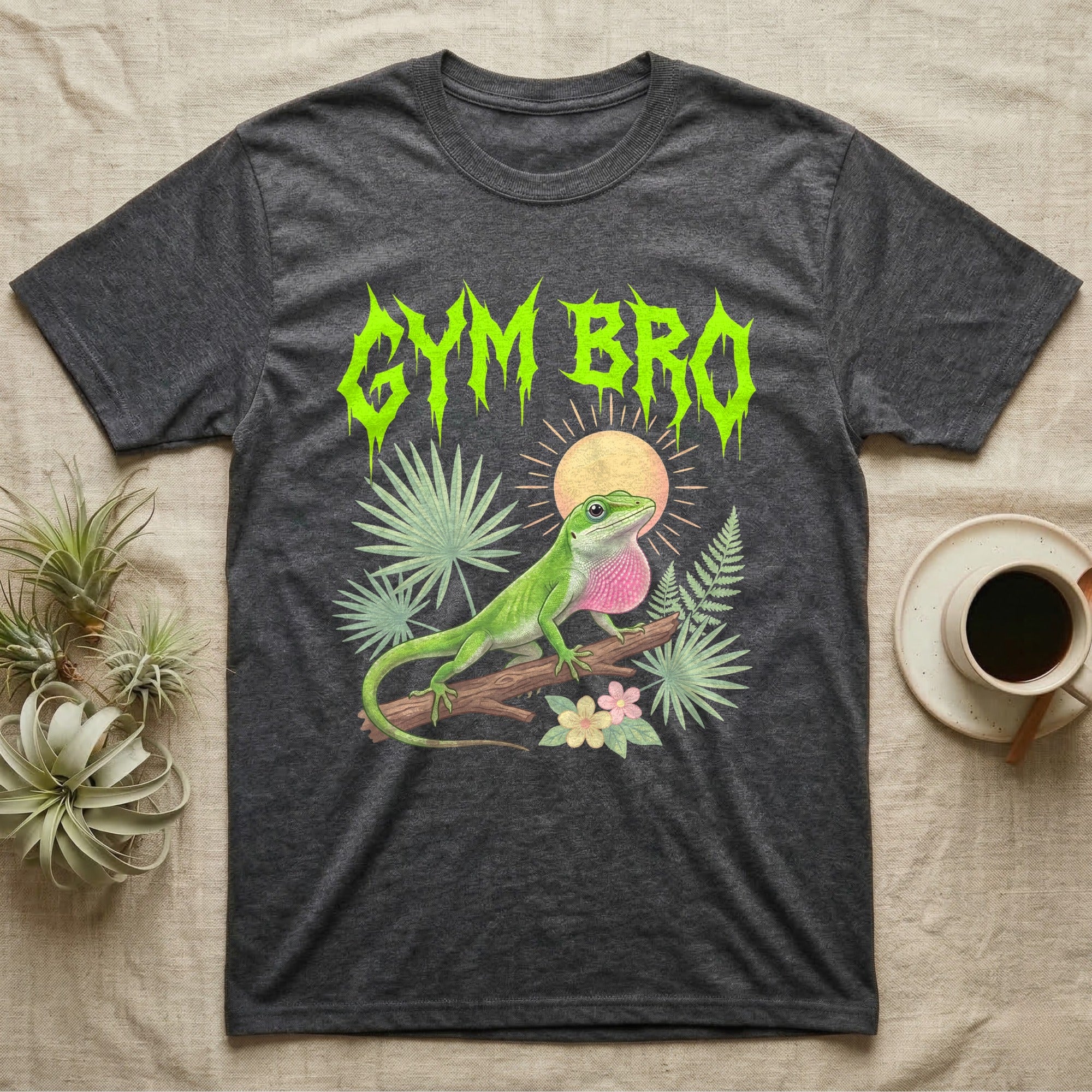 Green Anole Feral T-Shirt in Dark Heather — Green anole mid push-up with flared pink dewlap under a jagged neon-lime metal "GYM BRO" wordmark and pastel ferns.