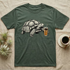 Slow Drip Tortoise T-Shirt in Military Green — Flat meme-style illustration of a sulcata tortoise reaching slowly toward a tall iced slow-drip coffee.