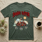 California Kingsnake Feral T-Shirt in Military Green — Banded California kingsnake coiled with a tiny companion snake under a jagged blood-red metal wordmark and pastel scene.