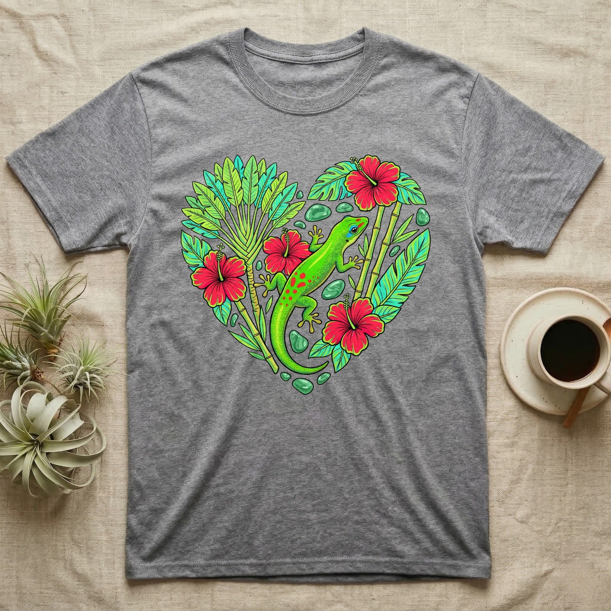 Grey t-shirt featuring a vibrant heart design with a green gecko, hibiscus flowers, and tropical leaves.