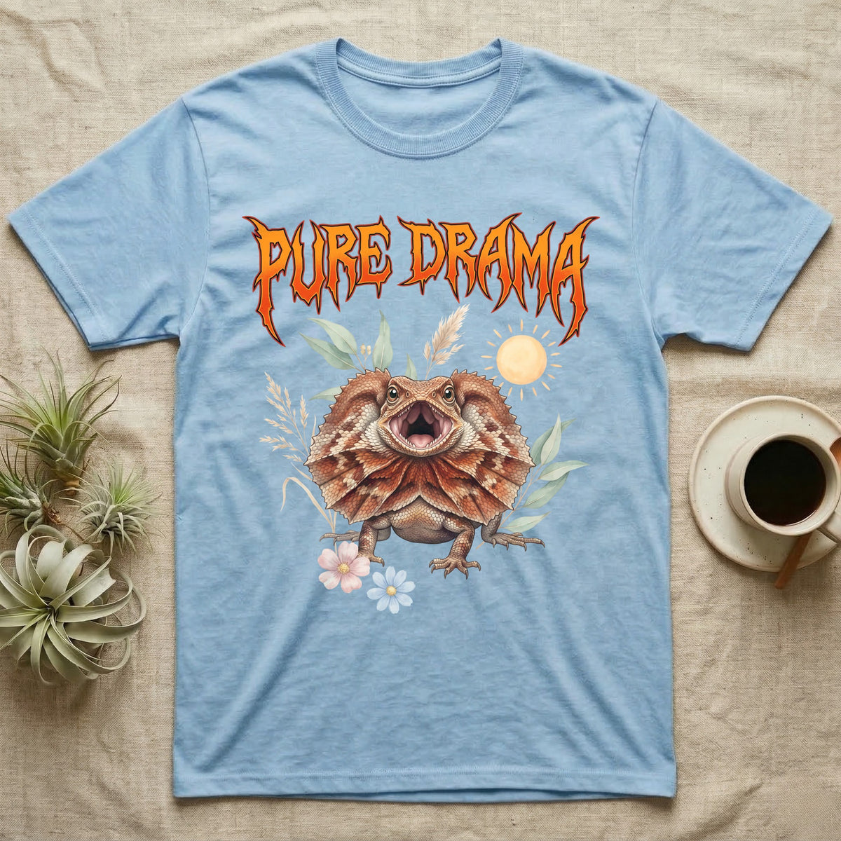 Frilled Dragon Feral T-Shirt in Light Blue — Frilled dragon with its neck frill flared and mouth gaping under a jagged fiery-orange metal "PURE DRAMA" wordmark.