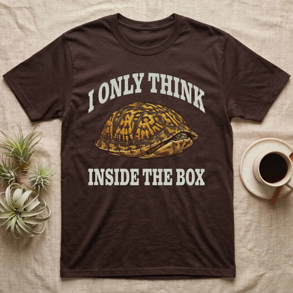 Box Turtle Thinker T-Shirt in Dark Chocolate — Engraved eastern box turtle shut in its shell, one eye peeking out, under I Only Think Inside the Box