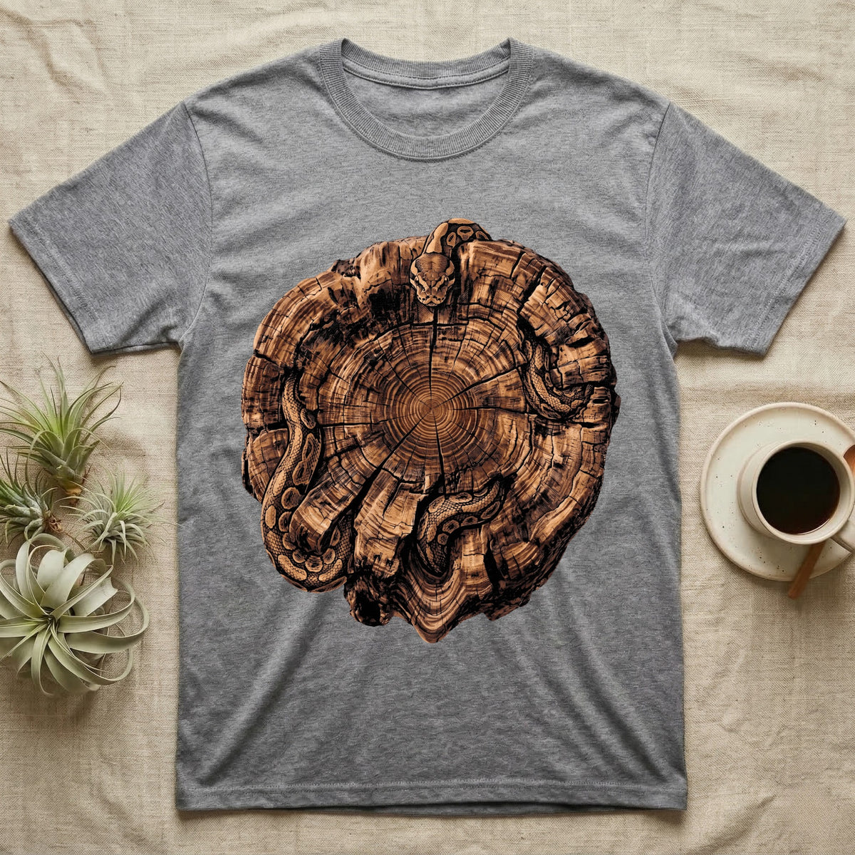 Ball Python Stump Coil T-Shirt in Sport Grey — Pyrography-style illustration of a ball python threaded through the charred radial cracks of a cross-section log, no on-shirt text.