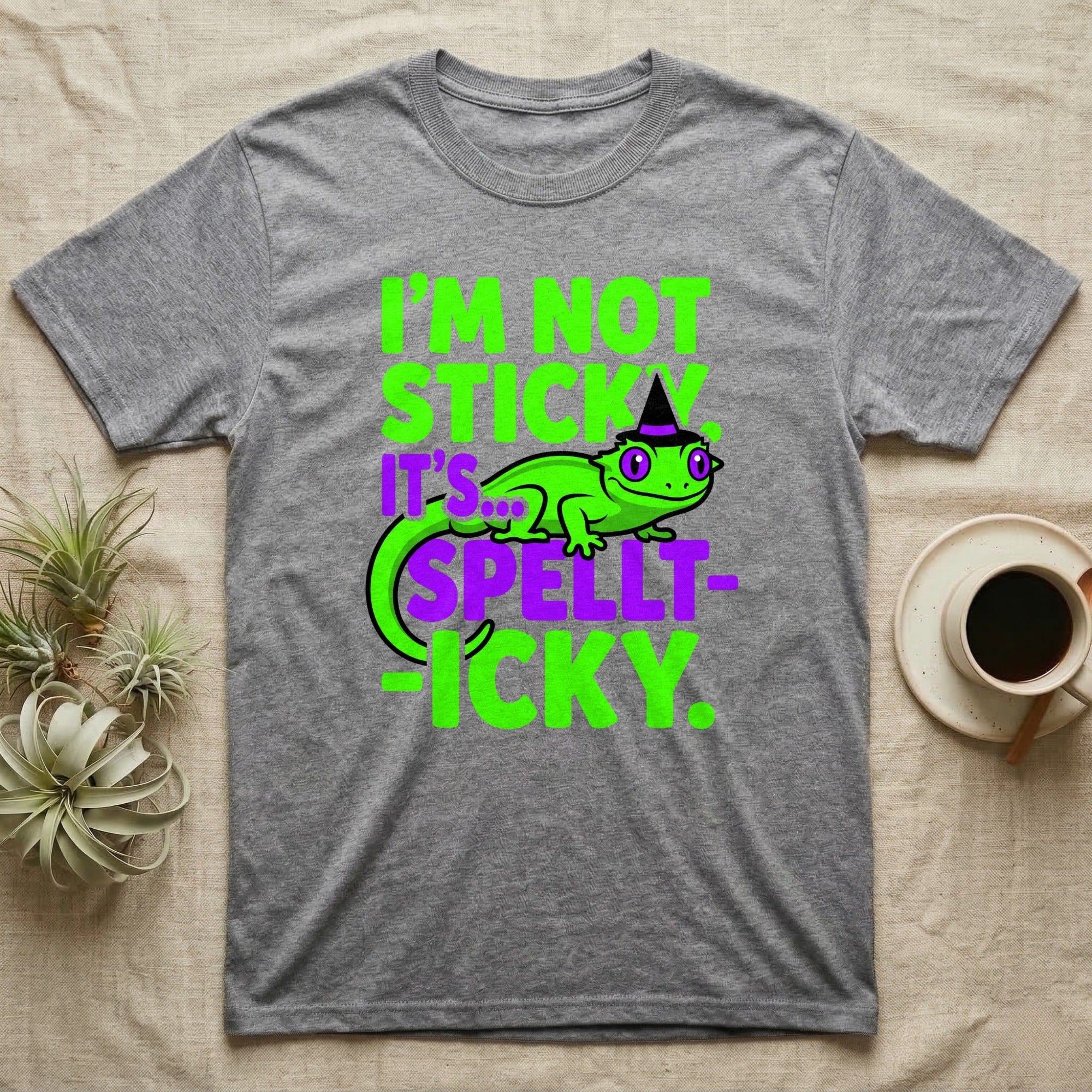 Crested Gecko Spellt-icky T-Shirt in Sport Grey — Neon cartoon crested gecko in a witch hat with stacked text, "I'm Not Sticky, It's Spellt-icky."