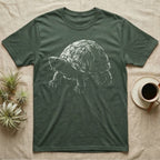 Musk Turtle Stinkpot T-Shirt in Military Green — Rim-lit negative-space illustration of a small musk turtle in badge-scale portrait against a dark ground.