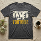 Owned By A Tortoise T-Shirt in Dark Heather — Distressed woodtype wordmark reading professionally owned by a tortoise in a bold two-tier lockup, text only.