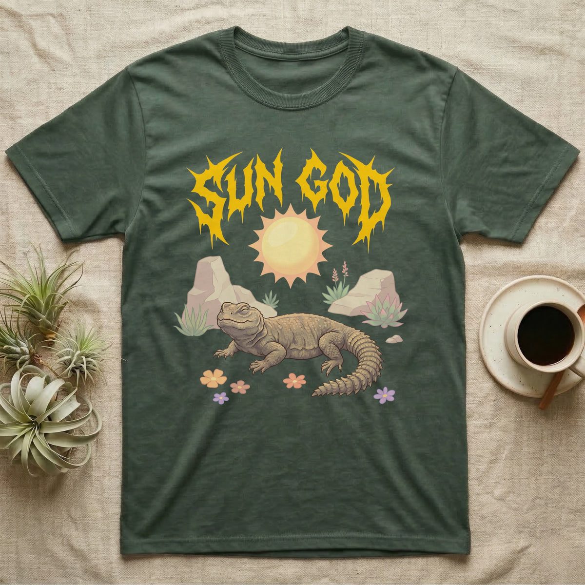 Moroccan Uromastyx Feral T-Shirt in Military Green — Moroccan uromastyx basking under a big sun with a jagged solar-gold metal "SUN GOD" wordmark and pastel desert scene.